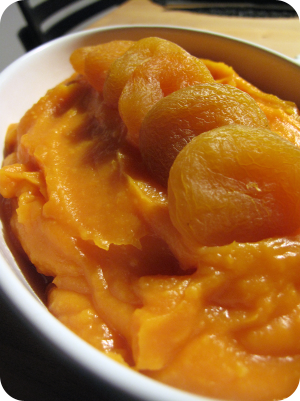 Bowl of orange mashed vegetable puree topped with dried apricot halves